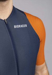 Bioracer cycling jersey featuring a navy body with an orange, textured sleeve and zip closure; logo printed on the chest.