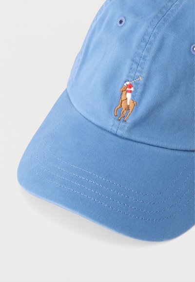 Ανοιχτό μπλε καπέλο μπέιζμπολ με κεντημένο λογότυπο ενός παίκτη πόλο σε κόκκινο, λευκό και καφέ χρώμα, πάνω σε άλογο, που κρατά ένα κοπίδι.
