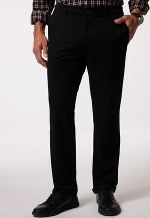 Zwarte broek met een rechte pasvorm, gemaakt van katoen. Voorzien van een knoopsluiting, voorkruiszakken en opgerolde manchetten. Draag je met zwarte sneakers.