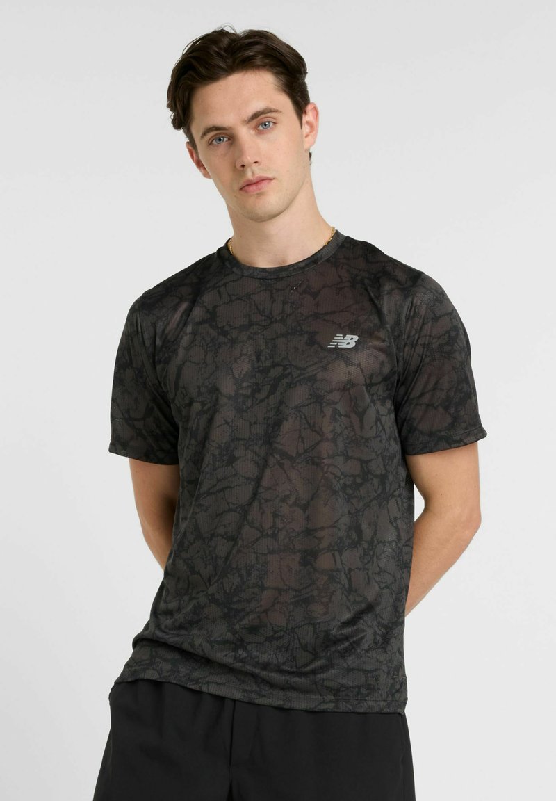 Black athletic t-shirt featuring a geometric pattern, short sleeves, round neckline, and a small reflective logo on the left chest.