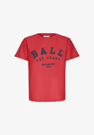 Red cotton t-shirt with short sleeves and a crew neck. Features bold navy text reading "BALL THE JEANS" and "ORIGINATED 1974."