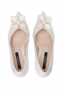 White flat shoes with a pointed toe, featuring a beige flower accent and pearl detail, crafted from smooth leather with a soft interior.