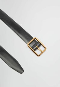 Schwarzer Ledergürtel mit einer quadratischen goldfarbenen Schnalle, mit glatter Textur und zugespitztem Ende, das das minimalistisches Design und die Hardware-Details hervorhebt.