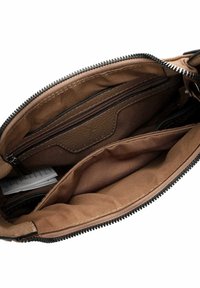 Interno di una borsa in pelle marrone con scomparti con cerniera, texture liscia e rivestimento in tessuto beige. Diversi taschini per l'organizzazione.