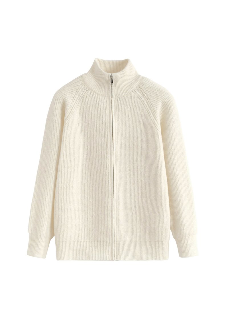 Pull en maille côtelée couleur crème avec un col haut et une fermeture éclair à l'avant. Il présente des épaules abaissées et des manches longues, avec un tissu texturé.