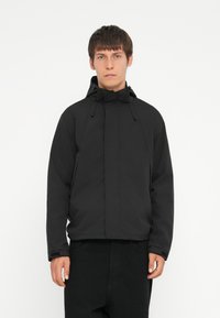 Schwarze, kapuzenjacke aus leichtem Material, mit einem vorderen Reißverschluss, verstellbaren Kordeln und einem lockeren Schnitt. Glatte Textur, keine Muster.