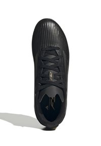Scarpa sportiva nera con tomaia testurizzata, caratterizzata da strisce verticali, design con lacci e dettagli in oro sulla linguetta e sul lato.