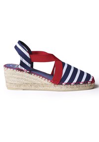 Marineblauwe en witte gestreepte canvas espadrille met rode elastische bandjes en een jute wigzool. Kenmerkt zich door rode stiksels langs de rand van de zool.