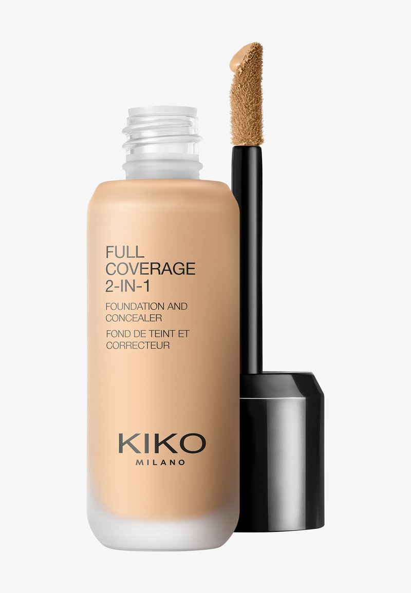 Flacon de fond de teint et correcteur 2-en-1 couvrance totale avec applicateur en baguette montrant le maquillage liquide beige sur la pointe du pinceau.
