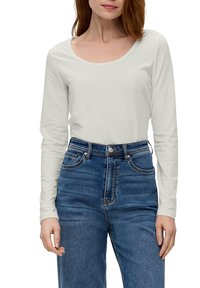 Vaaleanharmaa pitkähihaine paita, jossa on leveä pyöreä kaula-aukko, yhdistettynä korkeavyötäröisiin sinisiin farkkuihin, joissa on klassinen denimit texture ja ommel.