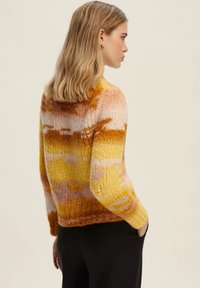 Maglione lavorato a maglia con un gradient di tonalità giallo, arancione e rosa, dalla vestibilità ampia, collo rotondo e orlo a costine. Dettaglio in filato testurizzato.