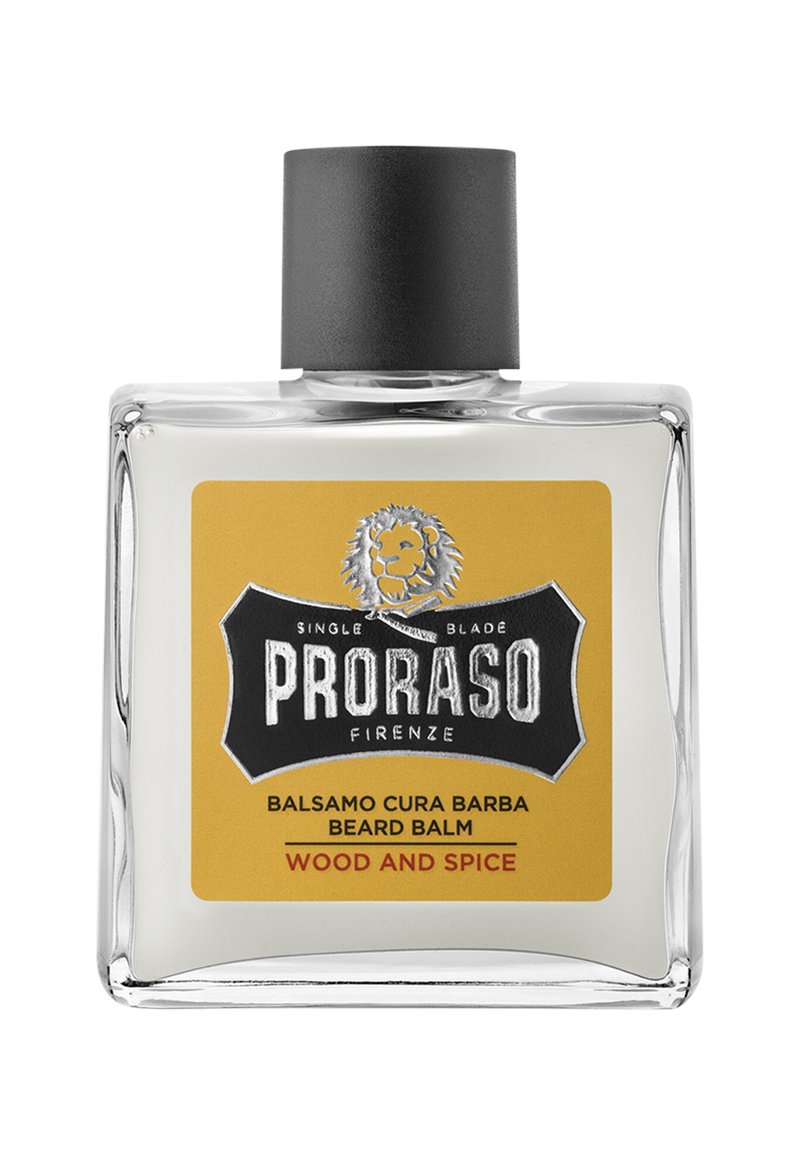 Skäggbalsam i en klar glasflaska med svart kork. Etiketten har en gul bakgrund med svart text och en lejonlogotyp.
