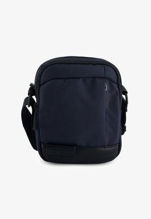 Compact navyblauwe crossbodytas met voorvak met rits, verstelbare zwarte band en zwarte leren bodempatch met het label "VENEZIA."