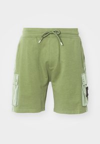 Grüne Baumwollshorts mit elastischem Bund und Kordelzug. Verfügt über zwei seitliche Cargo-Taschen und strukturierte Paneelakzente an den Seiten.