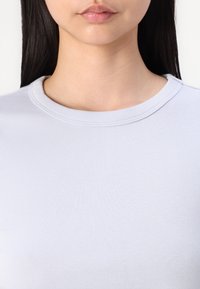 Lichtblauwe katoenen t-shirt met een ronde halslijn en ribbeltextuur, met een gladde oppervlakte en minimalistisch ontwerp.