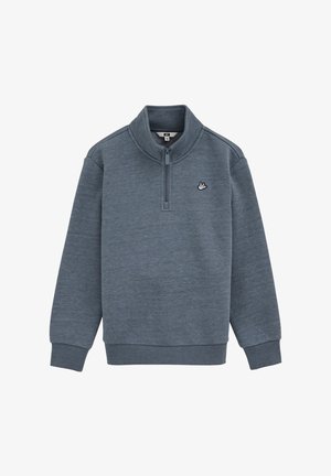 Sivá mikina vyrobená z mäkkého materiálu, ktorá má vysoký golier a polovičný zips. Obsahuje malé logo na ľavej hrudi a rebrované manžety.