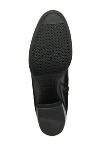 Suola di scarpa in pelle nera con gomma testurizzata per una presa ottimale, caratterizzata da una finitura liscia, una forma curva e un discreto marchio impresso.