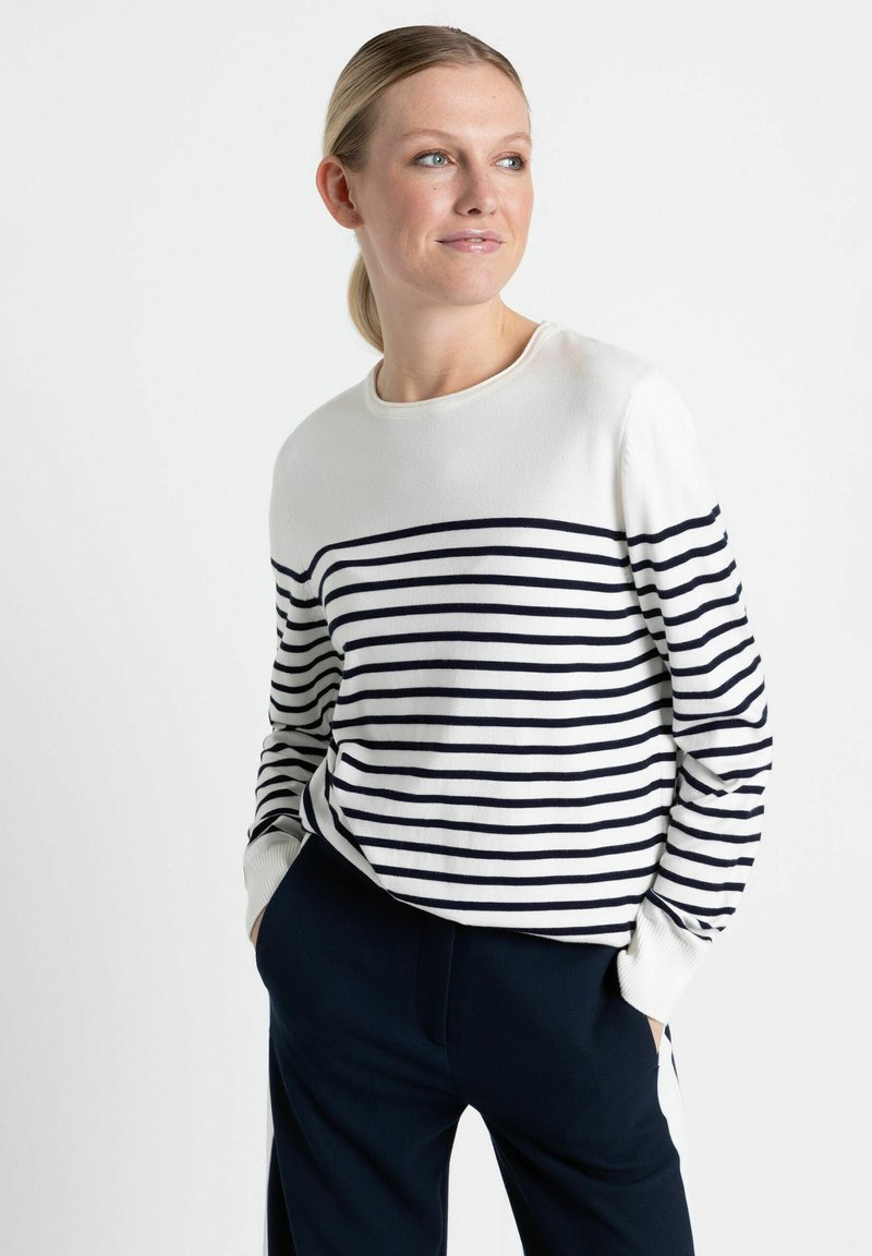 Weißer Pullover mit marineblauen horizontalen Streifen, rundem Ausschnitt und gerippten Bündchen, kombiniert mit marinen Hosen. Glattes Material, lockere Passform.