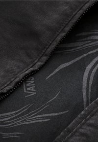 Black fabric with a smooth texture, featuring a subtle abstract pattern in gray. The edges have a stitched seam, adding durability.