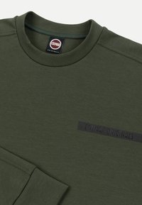 Dunkelgrünes Langarmshirt mit Rundhalsausschnitt und "Colmar Originals"-Etikett auf der Brust sowie Markentag innen am Kragen.
