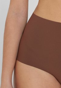 Braune hochtaillierte Unterwäsche aus glattem, elastischem Stoff, mit nahtlosem Design und einem breiten elastischen Bund für zusätzlichen Komfort.