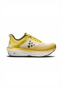 Baskets de course jaunes et blanches avec une tige en maille texturée, des points de logo noirs proéminents, des accents verts et une semelle blanche rembourrée.