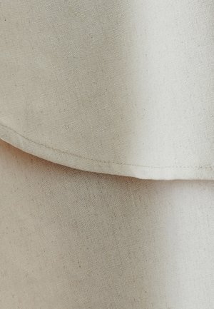 Bežinė lininė medžiaga su subtiliu tekstūru, turinti persidengiančias sluoksnius ir tiesią siuvimo liniją. Paviršius atrodo glotnus ir lengvas.