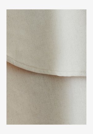 Bež lina kangas peene tekstuuriga, millel on kattuvad kihid ja sirged õmblused. Pind näeb välja sile ja kerge.