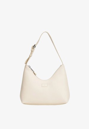 Borsa a tracolla in pelle color crema con forma curva, tracolla regolabile, chiusura con cerniera e piccolo logo rettangolare sulla parte anteriore. Texture liscia.