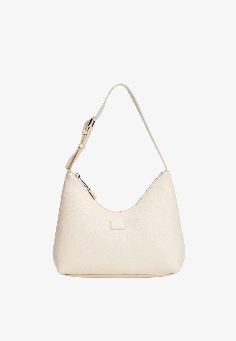 Kremfarvet skuldertaske i læder med en buet form, justerbar strop, lynlåslukning og et lille rektangulært logo foran. Glat tekstur.
