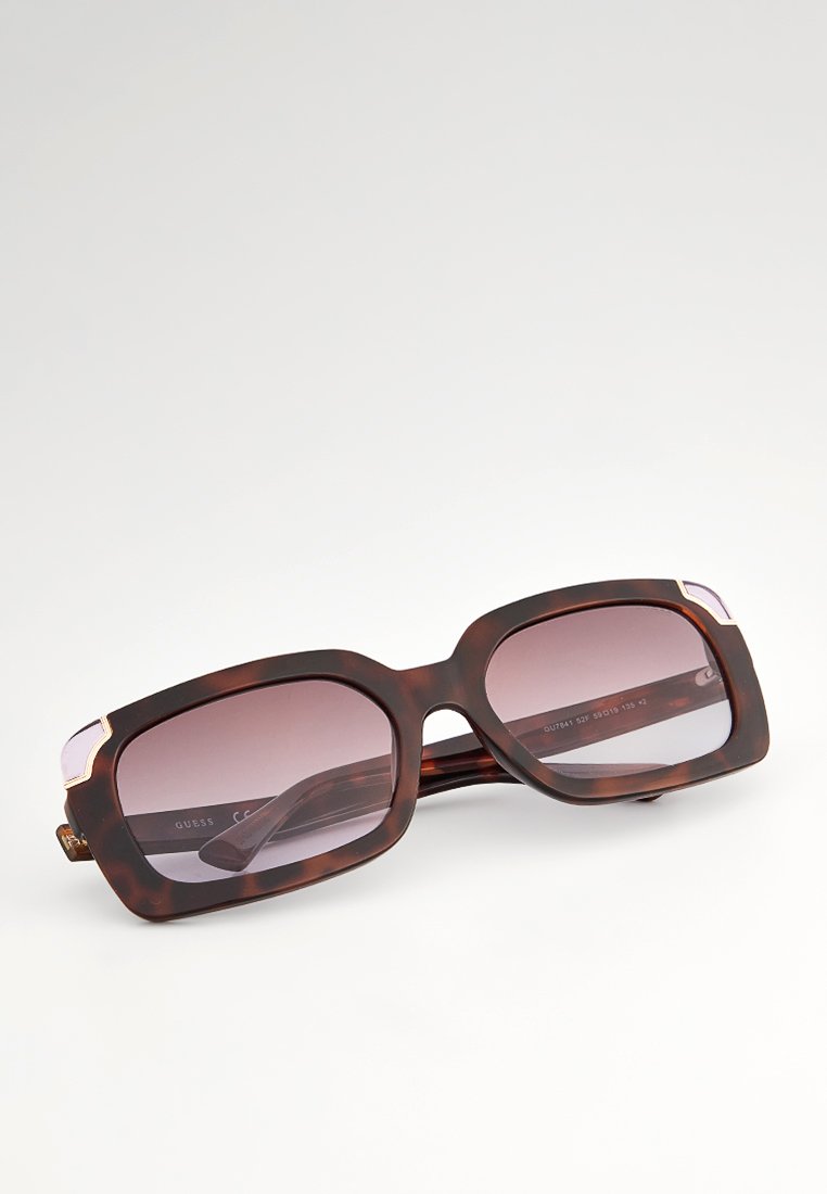 Übergroße rechteckige Sonnenbrille mit einem Schildpatt-Rahmen, gradienten Gläsern und goldenen Akzenten an den Bügeln. Strukturiertes Oberflächendesign.