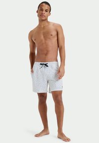 Λευκό μαγιό με πολύχρωμο μοτίβο κουκίδων, ελαστική μέση και μαύρο κορδόνι. Λείο υλικό, μήκους μέχρι το γόνατο.