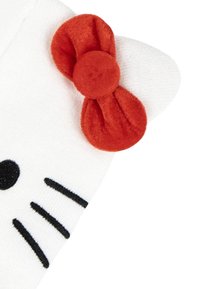 Witte stof met zwarte snorharen en neusdetails, voorzien van een gestructureerde rode strik in de bovenste hoek, die lijkt op een kat-gezicht ontwerp.