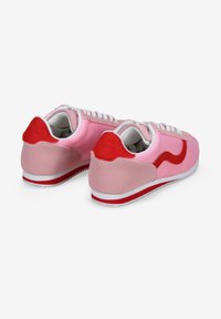 Zapatillas de deporte rosas y rojas con partes superiores de sintético suave, cordones blancos, cuellos acolchados, acentos rojos y suelas de goma blanca con huellas texturizadas.