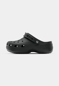 Sabot noir sans lacets avec des trous de ventilation, une semelle relevée et une bride de talon réglable avec un logo circulaire.