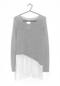 Maglia grigia a maniche lunghe con scollatura rotonda e orlo in chiffon bianco a strati. Tessuto in maglia morbido con una finitura leggermente lucida.