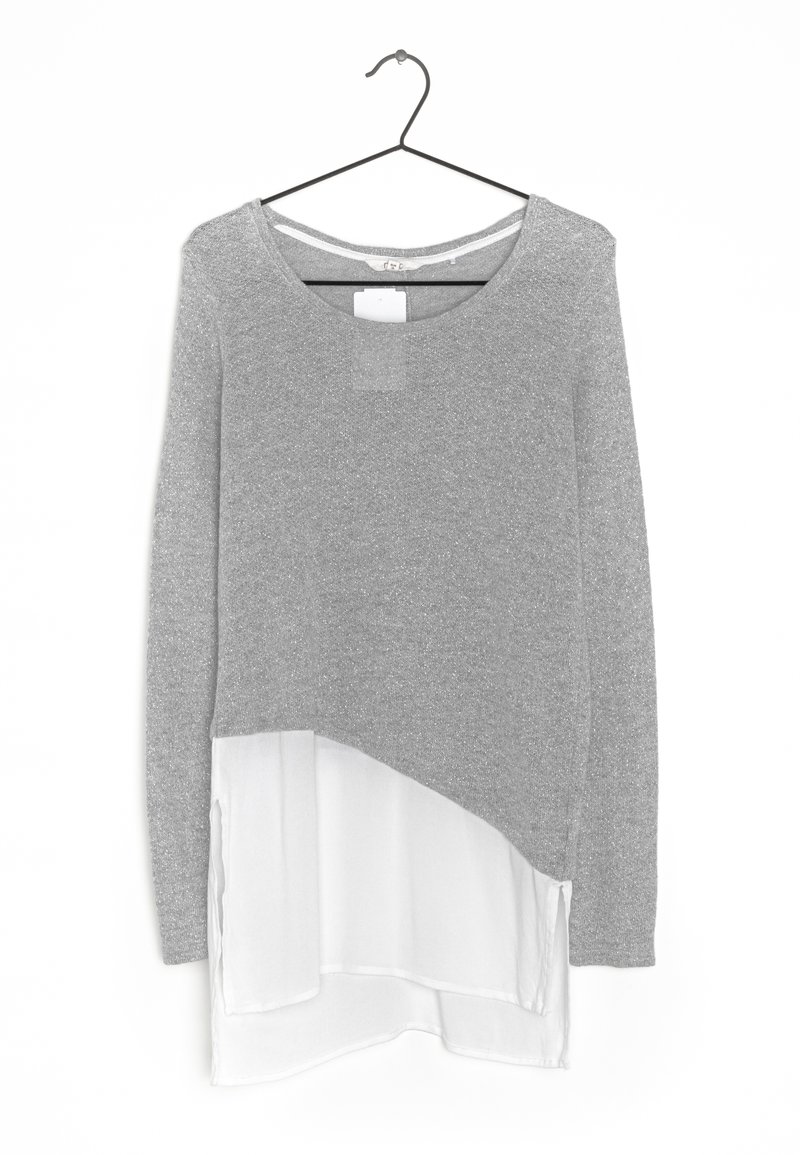 Maglia grigia a maniche lunghe con scollatura rotonda e orlo in chiffon bianco a strati. Tessuto in maglia morbido con una finitura leggermente lucida.