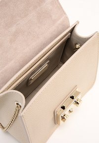 Borsa a mano in pelle beige con esterno testurizzato, dettagli in oro e interno spazioso foderato. Dotata di chiusura magnetica e tasca porta carte.