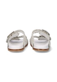 Sandalias blancas tejidas con una suela plana y suave, y correas decorativas trenzadas. Los acentos incluyen pequeñas cuentas metálicas en las correas.