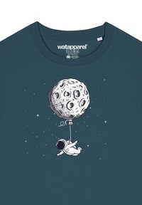 Donkerblauwe katoenen t-shirt met een bedrukte afbeelding van een astronaut die een ballon in de vorm van de maan vasthoudt, tegen een sterrenachtige achtergrond.