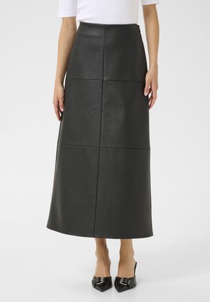 Gonna maxi nera in pelle con design a pannello rettangolare e texture liscia. Indossata con scarpe con tacco a punta nere per creare contrasto.