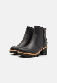 Bottes de cheville en cuir noir avec une fermeture éclair sur le côté, bout rond et semelle texturée. Présente une semelle intermédiaire brun contrastant et un talon épais.