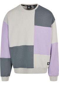 Bluza wykonana z mieszanki bawełny w luźnym fasonie, z kolorowymi blokami w odcieniach purpury, jasnoszarego i ciemnoszarego. Zawiera małą metkę z logo.