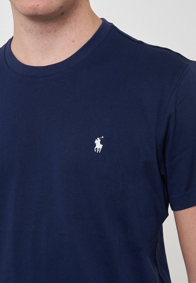 T-shirt in cotone blu navy con scollatura rotonda, maniche corte e un piccolo logo bianco raffigurante un giocatore di polo ricamato sul petto.