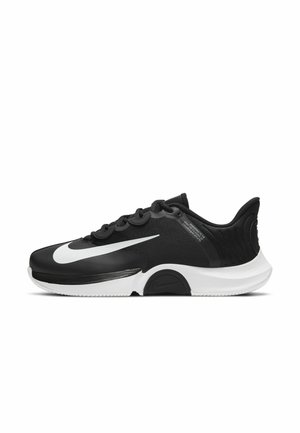 Black athletic shoe featuring a synthetic upper, white Nike swoosh, textured heel, and a contrasting white midsole. Low-profile design.