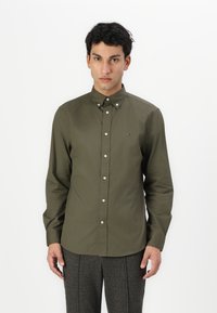 Camicia verde oliva con bottoni, colletto classico, vestibilità slim, maniche lunghe e bottoni bianchi, con un piccolo logo sul petto.
