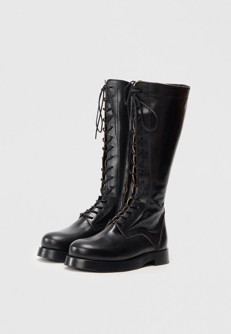 Black leather knee-high lace-up boots with a smooth texture, rounded toe, and contrasting stitching detail along the sides.