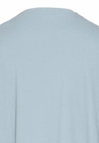 Lyseblå t-shirt, korte ærmer, rund halsudskæring, blød bomuldsstruktur, ingen synlige mønstre eller pynt, simpel og minimalistisk design.