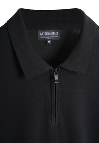 Crni pulover s ovratnikom na rajsferšlus, izrađen od super finog pređe od mješavine viskoze. Ima uski kroj i teksturirani pleteni dizajn.