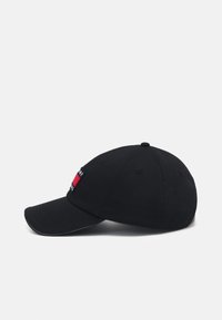 Cappellino da baseball in cotone nero con visiera curva, caratterizzato da una piccola toppa logo rossa e blu sul davanti e diversi fori di ventilazione.